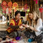 A foreign woman tourist making crafts during a workshop with local people, learning traditional techniques and creating her own handmade items