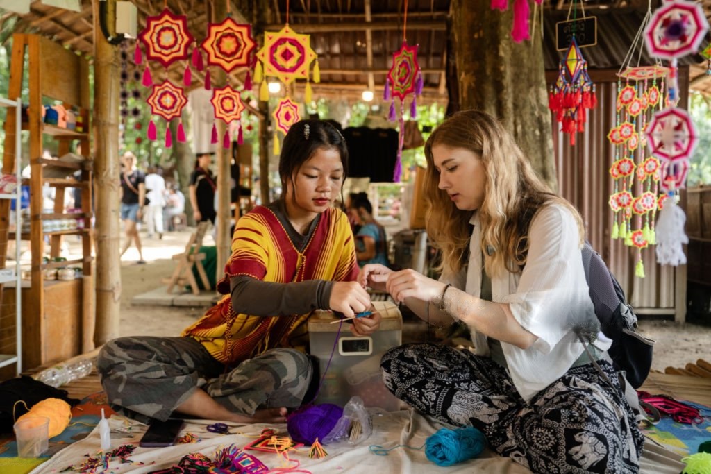 A foreign woman tourist making crafts during a workshop with local people, learning traditional techniques and creating her own handmade items